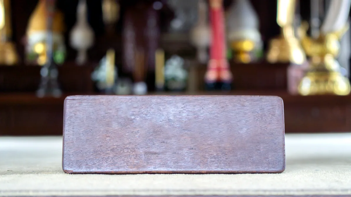 A small brass plaque bearing a destroyer's name resting on a velvet-lined display shelf.